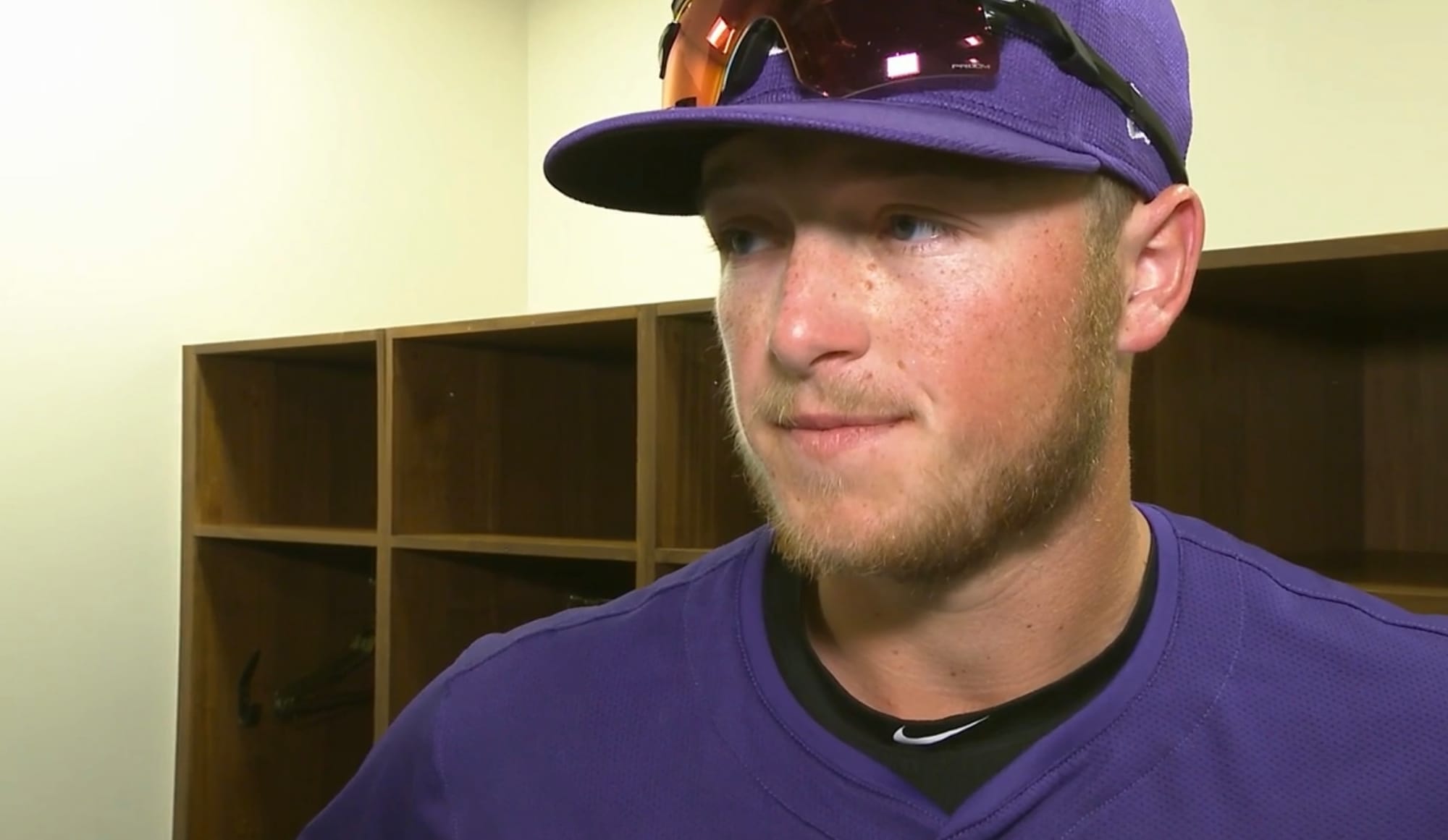 Hunter Goodman meets with the press at spring training. He’s wearing purple with some mirror shades resting on the brim of his hat.