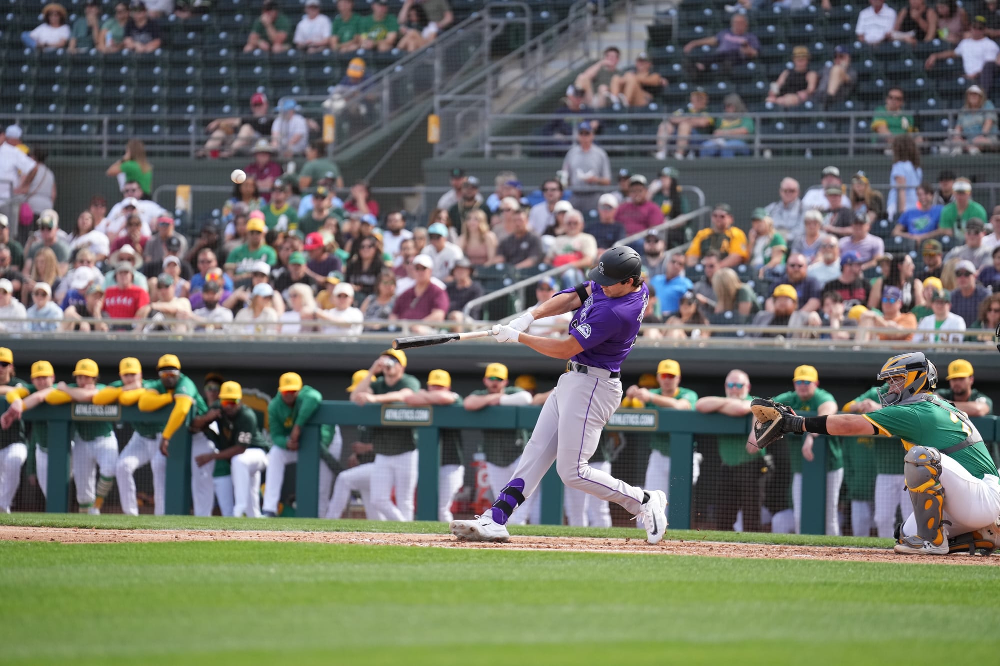 This photo shows Michael Toglia swinging from the left side of the plate. He’s wearing a purple jersey. 