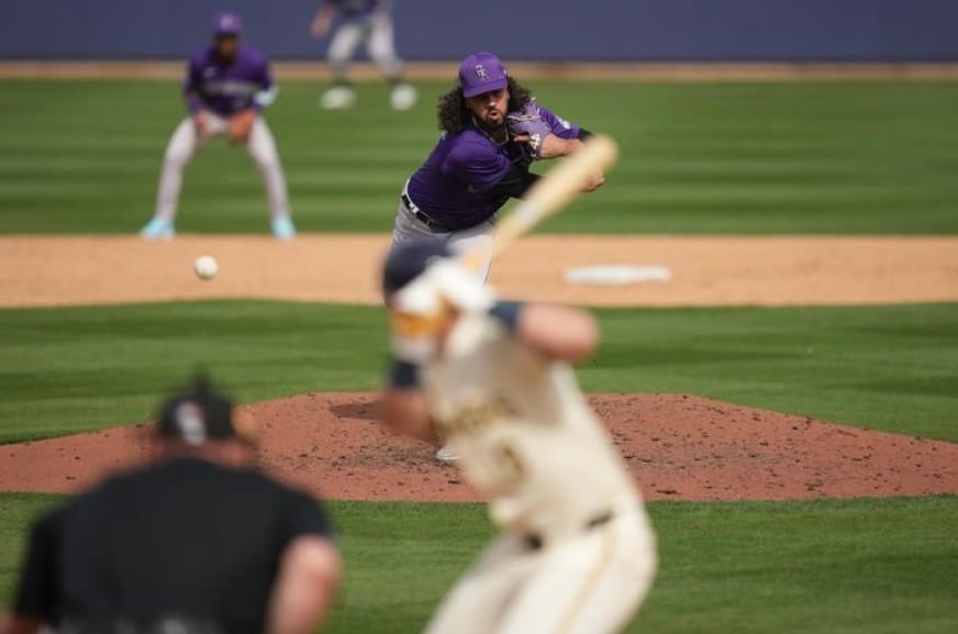 This photo from behind the plate shows Justin Lawrence releasing a piece. He’s wearing a purple jersey and looking fierce as the ball sweeps.