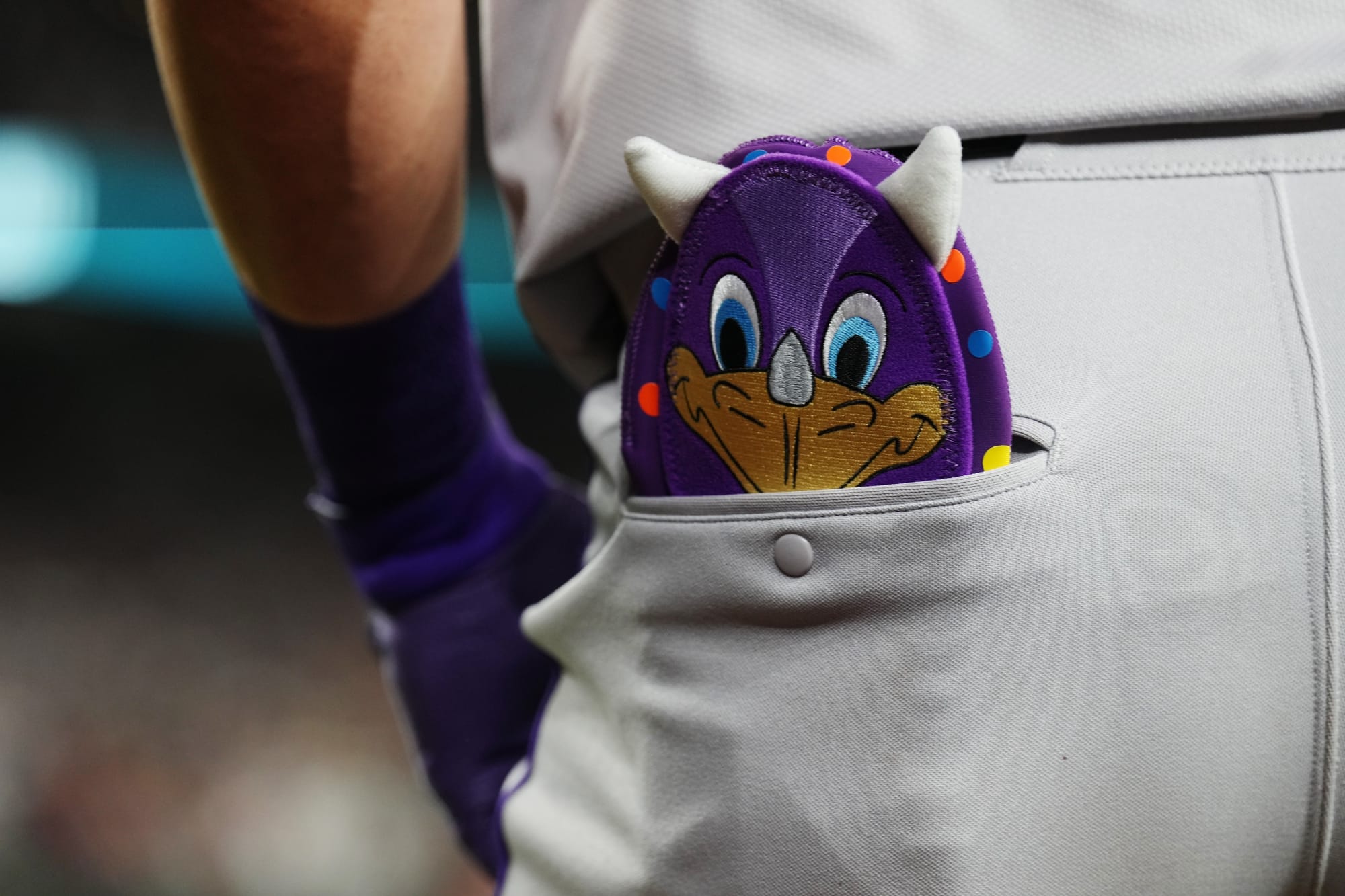 Nolan Jones’ sliding mitt shows from his pants’ pocket. It’s purple and features dinger — complete with protruding dinosaur horns.