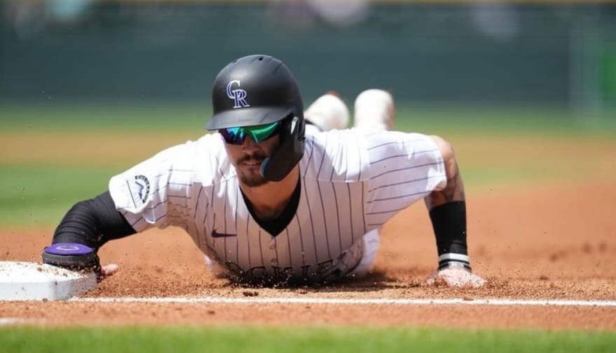 Brenton Doyle reaches for the bag, sliding into their on his stomach. He’s wearing purple pinstripes and some very cool mirrored sunglasses.