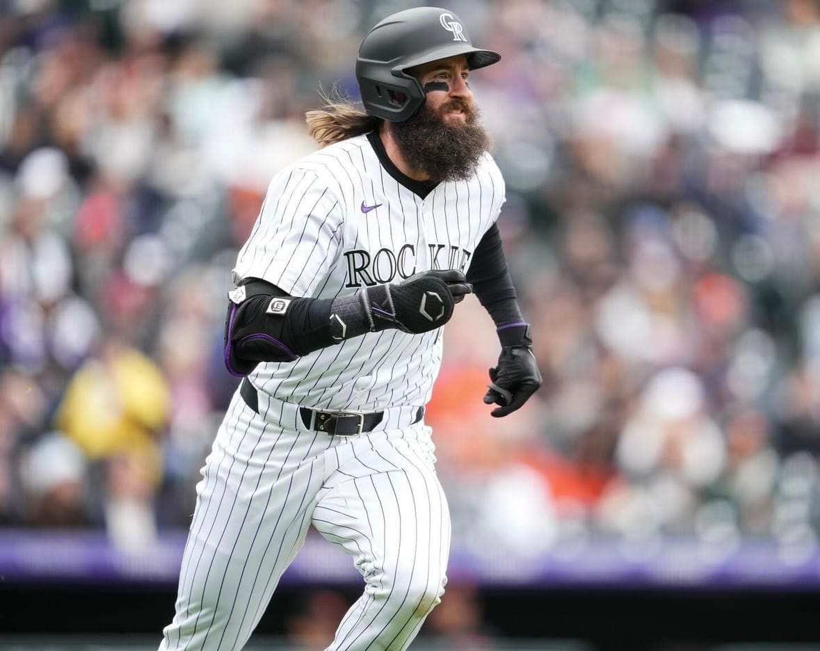 Charlie Blackmon runs to first. He’s wearing purple pinstripes.