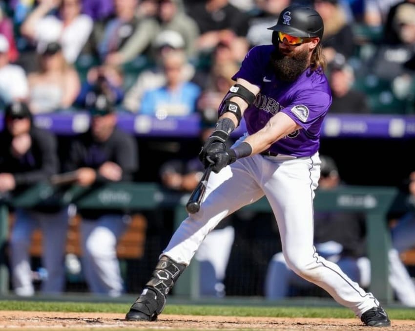 Charlie Blackmon swings at a pitch. He’s wearing a purple jersey.