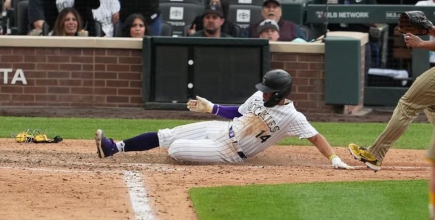 Ezequiel Tovar slides into home at Coors Field in Thursday’s defeat of the San Diego Padres. he’s wearing purple pinstripes.