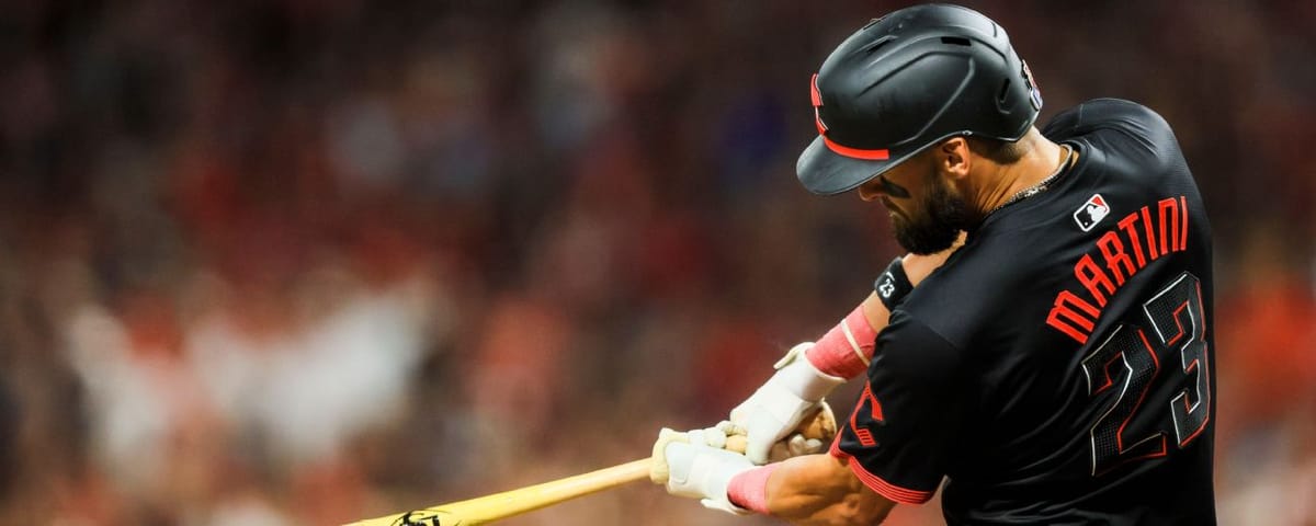 Nick Martini takes a swing. He’s wearing a black Reds jersey and batting helmet.