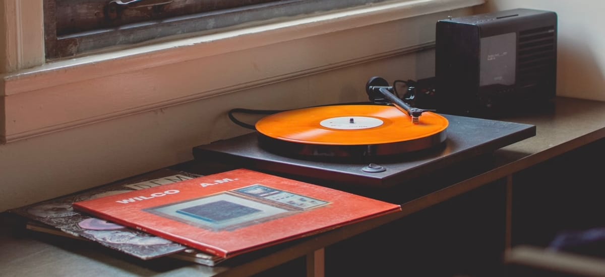 Wilco’s ”AM” album sleeve and an orange record on a record player.