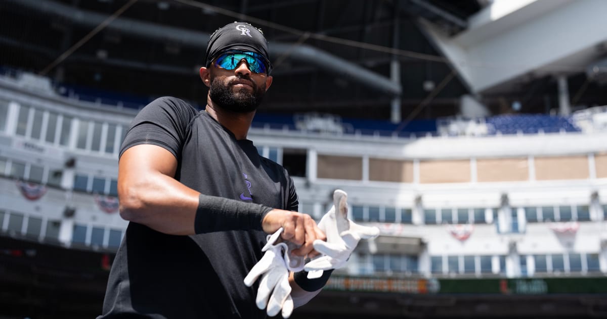 Willi Castro puts on batting gloves at the Marlins stadium.