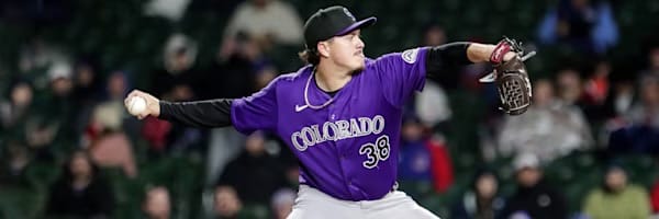 Victor Vodnik prepares to pitch. He is wearing a purple Rockies jersey.