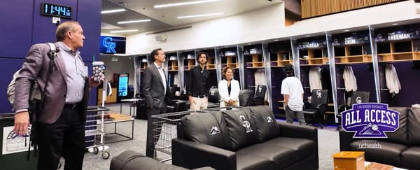 Paul DePodesta and his family (and Dick Monfort) tour the Rockies’ clubhouse.