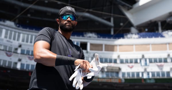 Willi Castro puts on batting gloves at the Marlins stadium.
